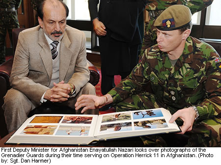 First Deputy Minister for Afghanistan Enayatullah Nazari looks over photographs of the Grenadier Guards during their time serving on Operation Herrick 11 in Afghanistan. (Photo by: Sgt. Dan Harmer)