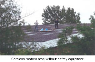 Careless roofers atop without safety equipment